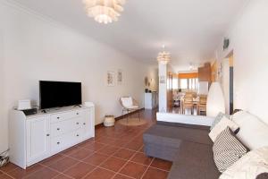 a living room with a tv on a white cabinet at Santa Luzia Apartment Sl016 in Santa Luzia