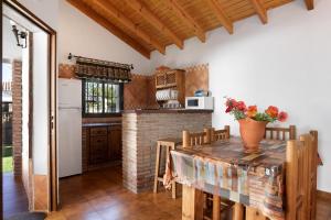 a kitchen with a wooden table and a brick fireplace at Casa Alberto in Zahora