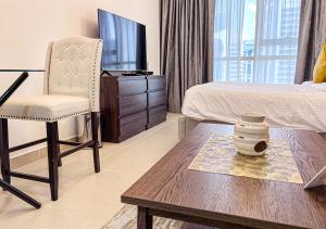 een woonkamer met een bed, een tafel en een stoel bij Cosmos Living Modern Studio Near Dubai Marina in Dubai