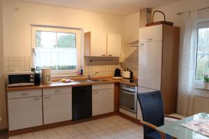 a kitchen with a white refrigerator and a sink at Ferienwohnung Coco in Tossens
