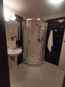 a bathroom with a shower and a sink at Apartament Perła 22 Jezioro Pluszne in Mörken