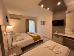 a hotel room with two beds and a television at Chrispy Waterpark Resort - All inclusive in Kolymvari