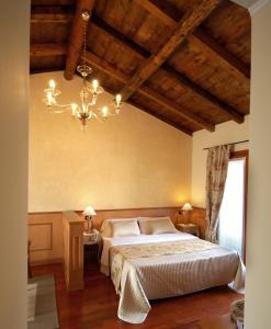 a bedroom with a large bed and a chandelier at Hotel Isola Di Caprera in Mira