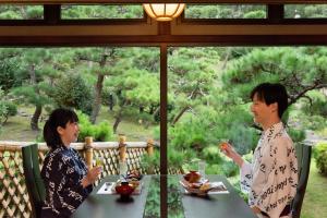 two women sitting at a table in front of a window at Hotel Hagoromo in Shizuoka