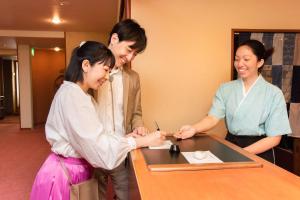 a group of three people standing around a table at Hotel Hagoromo in Shizuoka