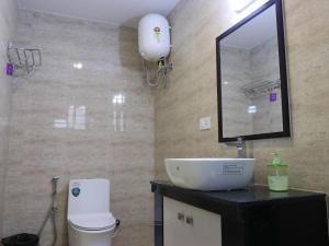 a bathroom with a sink and a mirror and a toilet at Cloud Walk in Kodaikānāl