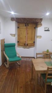 a room with a green chair and wooden tables at Lisbon Rossio Typical Apartments in Lisbon