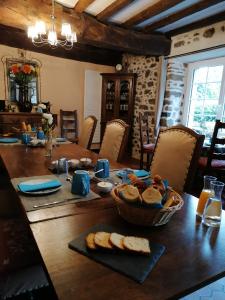 ein Tisch mit Brot und ein Korb mit Brot darauf in der Unterkunft Chambres d'Hôtes Au Clos du Lit in Lamballe