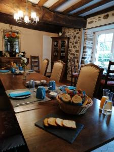 a table with bread and a basket of bread on it at Chambres d'Hôtes Au Clos du Lit in Lamballe