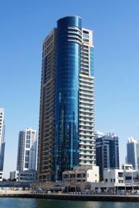 a tall skyscraper in the middle of a city at HiGuests - Modern Apt in Dubai Marina With Pool and Gym in Dubai