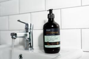 a bottle of black soap sitting on a bathroom sink at SoHot Stays - Sea Views From Every Room in Westgate on Sea