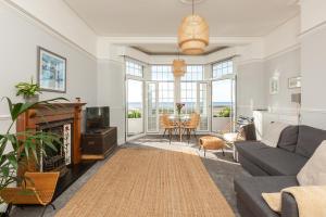 a living room with a couch and a tv at SoHot Stays - Sea Views From Every Room in Westgate-on-Sea
