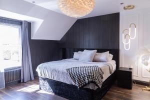1 dormitorio con 1 cama grande y pared negra en Luxurious 4BD family Retreat in Magherafelt, en Maghera