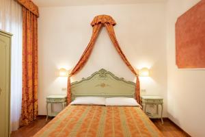 una camera con un letto verde con due tavoli di Hotel al Sotoportego a Venezia