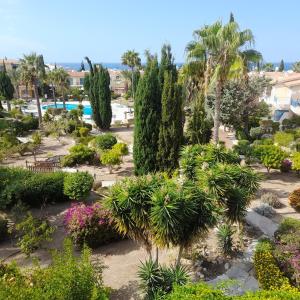 un giardino con palme e fiori in un resort di Modern Penthouse Sea View apartment Regina Gardens a Paphos