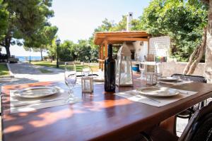 una mesa de madera con una botella de vino y copas en Seaside Haven Kineta, en Kineta