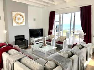 ein Wohnzimmer mit einem Sofa und einem Tisch in der Unterkunft Signature Lodge 3 @ Pinnacle Point Golf Estate in Mossel Bay