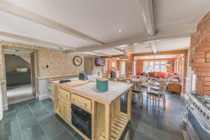 a kitchen and living room with a dining room and a table at Sandbeds Farmhouse in Kendal