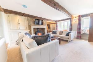 a living room with a white couch and a fireplace at Sandbeds Farmhouse in Kendal
