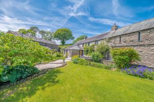an exterior view of a house with a garden at Sandbeds Farmhouse in Kendal