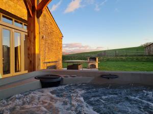 a jacuzzi tub with a view of a building at Keld Barn, Low Ploughlands Holiday Lets in Kirkby Stephen