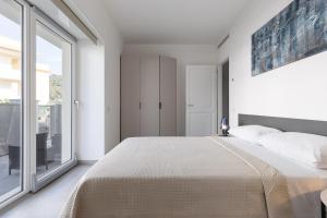 a bedroom with a large bed and a large window at Oneweek Gaeta Suites and Apartments in Gaeta