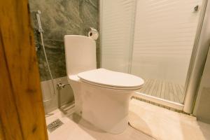 a white toilet in a bathroom with a shower at Madonna Hometel and Suites New Pandan in Panabo