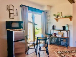 uma cozinha com uma mesa, um frigorífico e uma janela em NEW! Prickly Pear Unique Studio with bathroom built into the rocks em Prescott