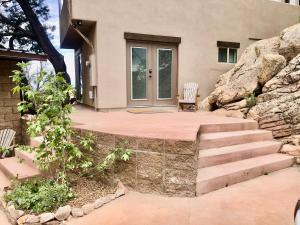 a house with a stone staircase leading to a front door at NEW! Prickly Pear Unique Studio with bathroom built into the rocks in Prescott