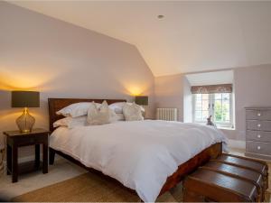 a bedroom with a large bed with white sheets and pillows at Stow House in Stow on the Wold