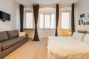 ein Wohnzimmer mit einer Couch und einem Bett in der Unterkunft Lauben Apartment Bolzano in Bozen