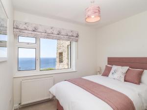a bedroom with a large bed and a window at Boscregan in Helston
