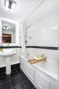 uma casa de banho com uma banheira branca, um lavatório e uma banheira. em The Crown Hotel, Boroughbridge, North Yorkshire em Boroughbridge