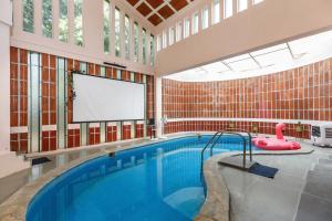 uma grande piscina com um ecrã num edifício em Rustic Farm in Hosur By JadeCaps Private Pool, Projector, AC, Wifi em Kelamangalam