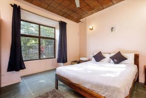 um quarto com uma cama e uma janela em Rustic Farm in Hosur By JadeCaps Private Pool, Projector, AC, Wifi em Kelamangalam