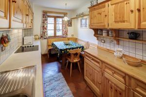 a kitchen with wooden cabinets and a table with a dining room at Villa Marianna - Stayincortina in Cortina dʼAmpezzo