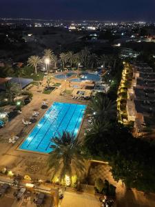 widok na basen w nocy w obiekcie Jericho Resort Village w mieście Jerycho