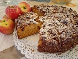 a cake on a plate with apples on a table at Camere Nordest Sudest- Conca Agordina in Agordo
