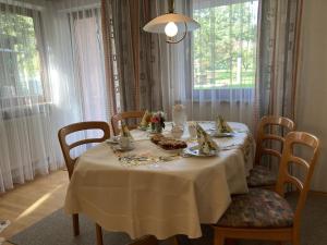 a dining room table with a white table cloth and chairs at Ferienwohnung Singer in Schnaittach