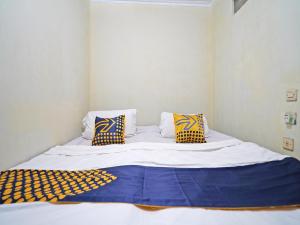 Tempat tidur dalam kamar di SPOT ON 91783 Urban Syariah Residence