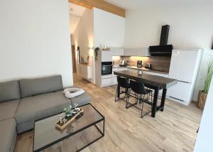 a living room with a couch and a table and a kitchen at Palais Karl-Theodor in Rottach-Egern