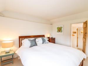 a bedroom with a large white bed with two pillows at Wherry Cottage in Manningtree