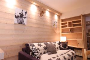 uma sala de estar com um sofá e uma parede de madeira em Tignes le Lac - Le Santon bel appartement 4 pers em Tignes