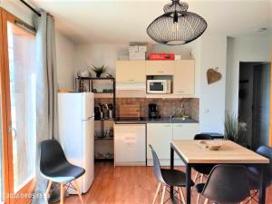Una cocina y un comedor con mesa y sillas. en Chalet spacieux 4 pièces - 9 pers, balcon, cuisine équipée, animaux ok - FR-1-504-644, en Superdevoluy
