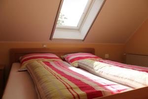 ein Bett mit zwei Kissen und einem Fenster in der Unterkunft Ferienwohnung Höpken 