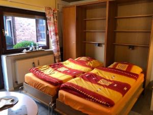 um quarto com 2 camas individuais e uma janela em Ferienwohnung "Roter Sand" em Burhave
