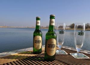 two bottles of beer sitting on a table with wine glasses at Hausboot Fritz im Wangermeer in Wangerland