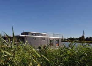 una casa sentada sobre un cuerpo de agua en Hausboot Fritz im Wangermeer en Wangerland