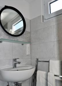 een badkamer met een wastafel, een spiegel en handdoeken bij Hausboot Fritz im Wangermeer in Wangerland