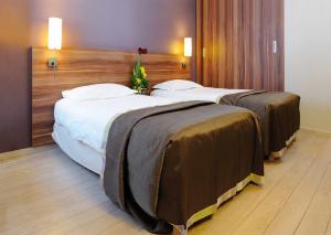 ビュール・シュリヴェットにあるレジドホーム ビュール ラ ガイヨネリーの茶色のカバーが付いたホテルルームのベッド2台